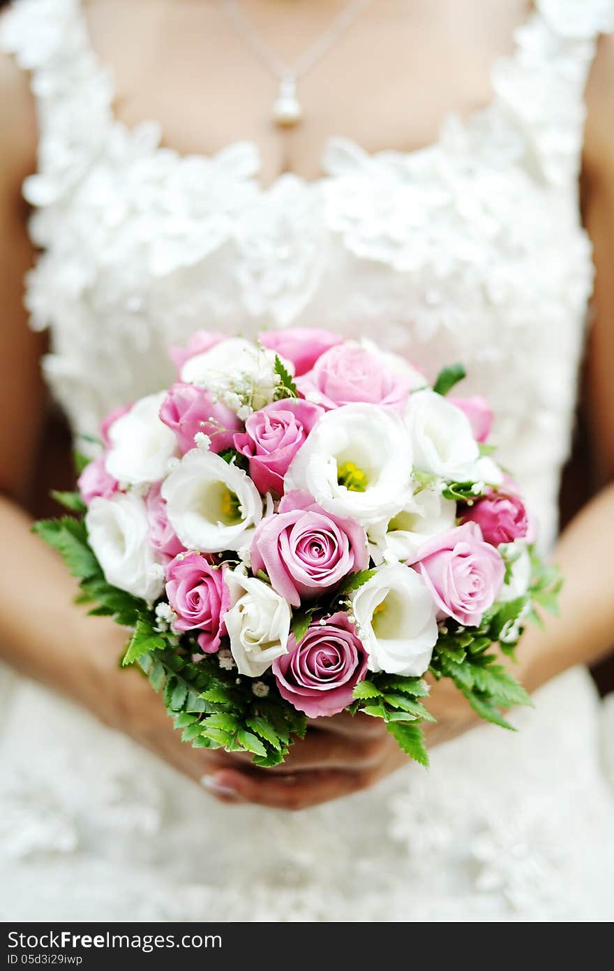 Beautiful wedding bouquet of pink roses in the hands of the bride. Beautiful wedding bouquet of pink roses in the hands of the bride