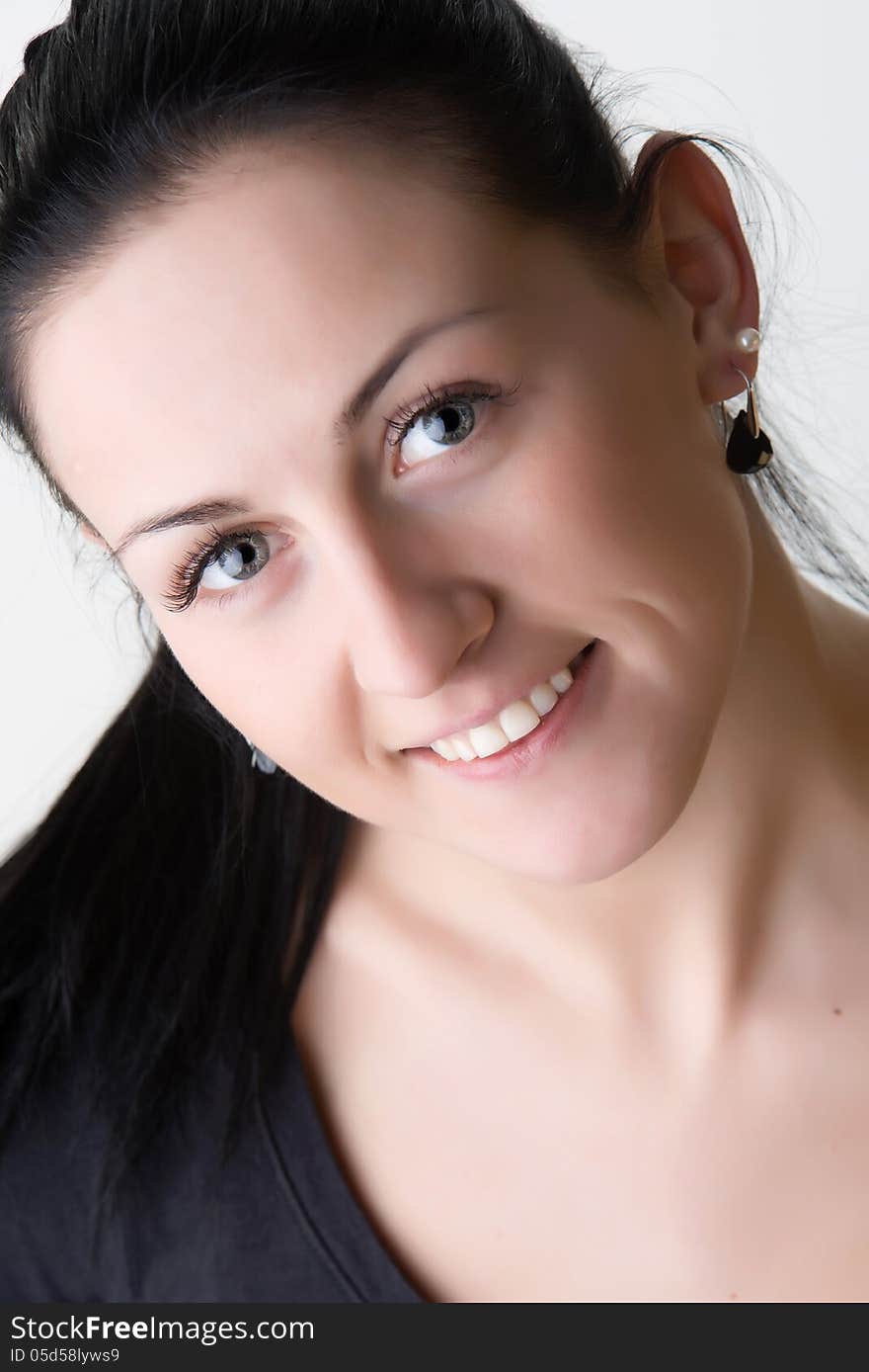 Close up portrait of lovely cheerful brunette girl looking up and smiling. Shot in studio. Isolated on white background. Close up portrait of lovely cheerful brunette girl looking up and smiling. Shot in studio. Isolated on white background.