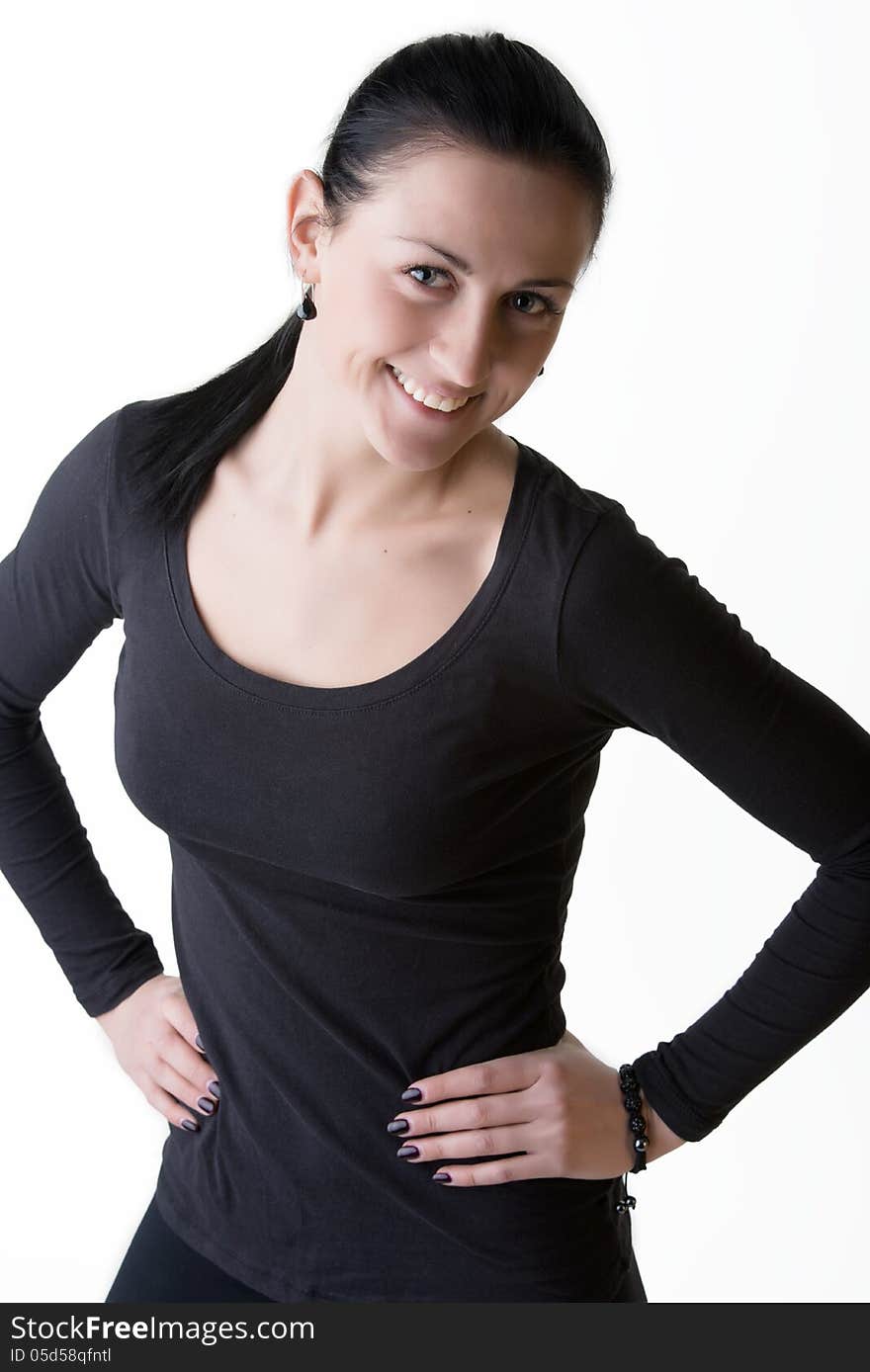 Portrait of young woman in black standing with arms on hips, looking playfully with sweet smile. Shot in studio. Isolated on white. Portrait of young woman in black standing with arms on hips, looking playfully with sweet smile. Shot in studio. Isolated on white.