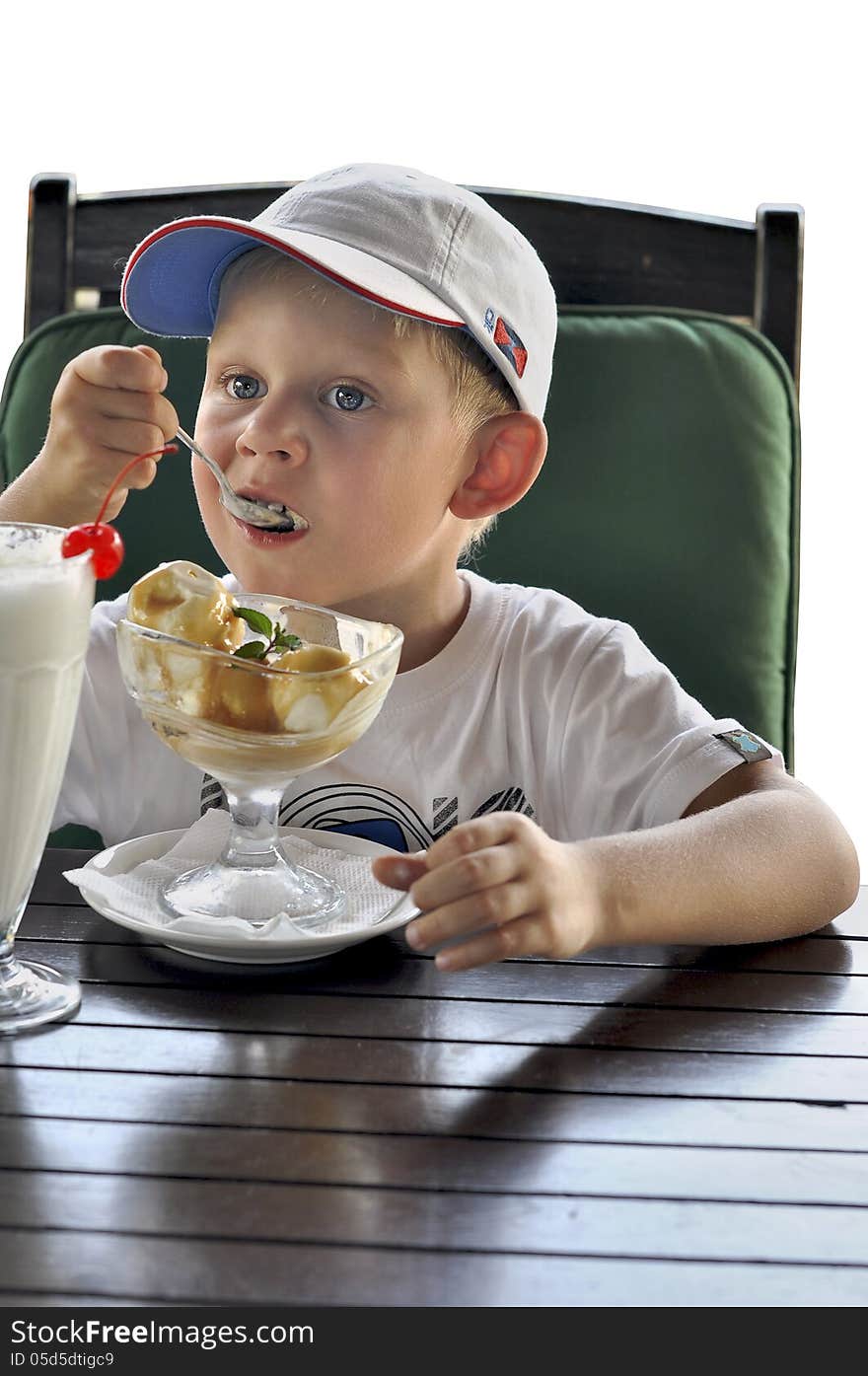 Boy in a baseball cap on a white background,boy eating ice cream. Boy in a baseball cap on a white background,boy eating ice cream