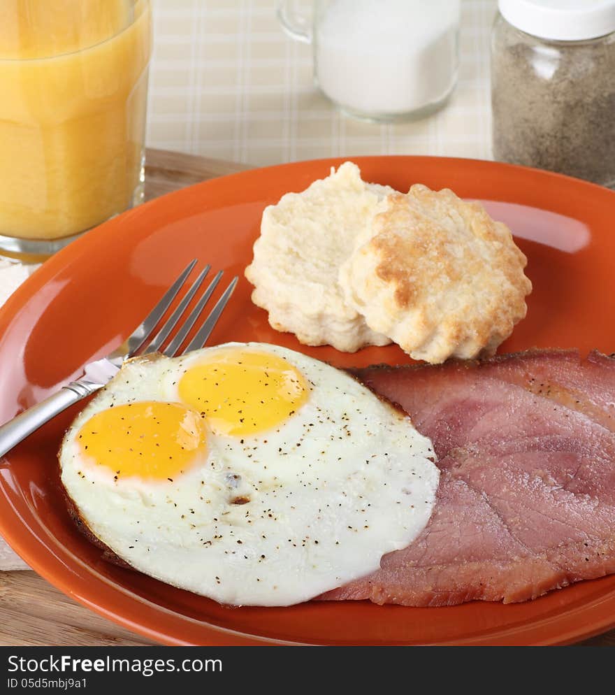 Breakfast of two fried eggs sunny side up and slice of ham. Breakfast of two fried eggs sunny side up and slice of ham