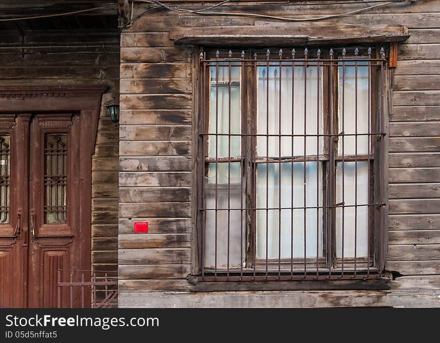 Horizontal photo of a wooden building window and door. There is a blank number plate. The wood walls are raw and unpainted. Horizontal photo of a wooden building window and door. There is a blank number plate. The wood walls are raw and unpainted.