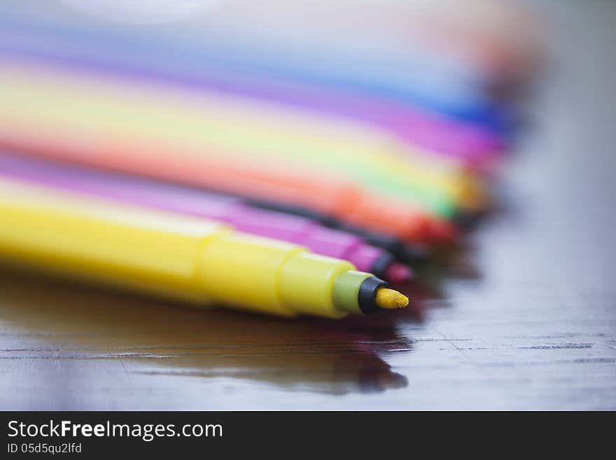 Colored markers lie in a row on the table