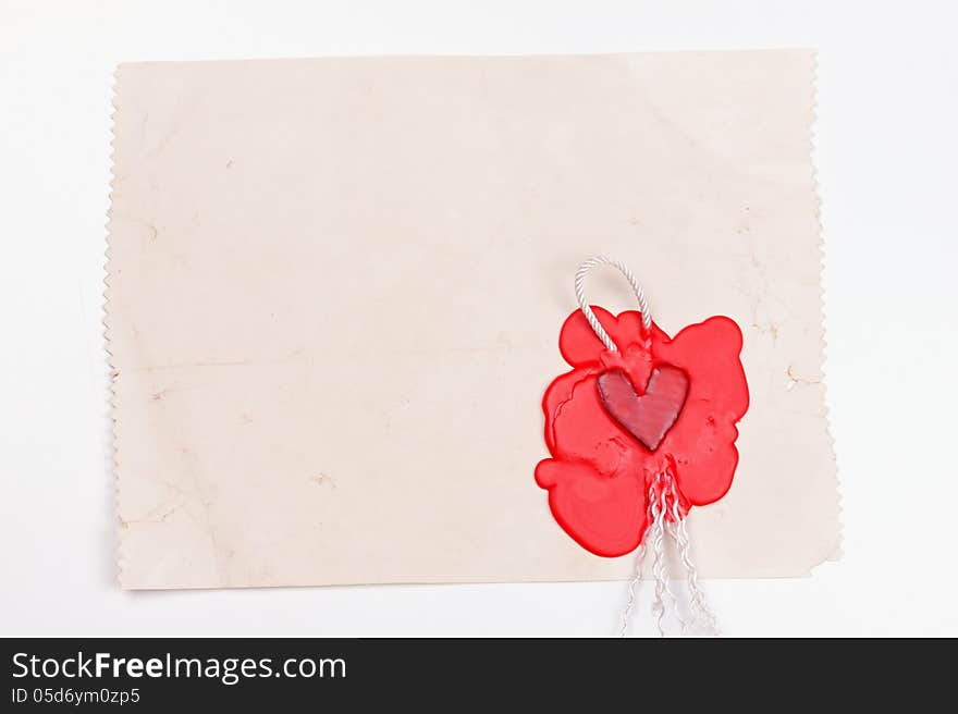 Mark in the shape of a heart made ​​of red wax on the background of old paper. Mark in the shape of a heart made ​​of red wax on the background of old paper