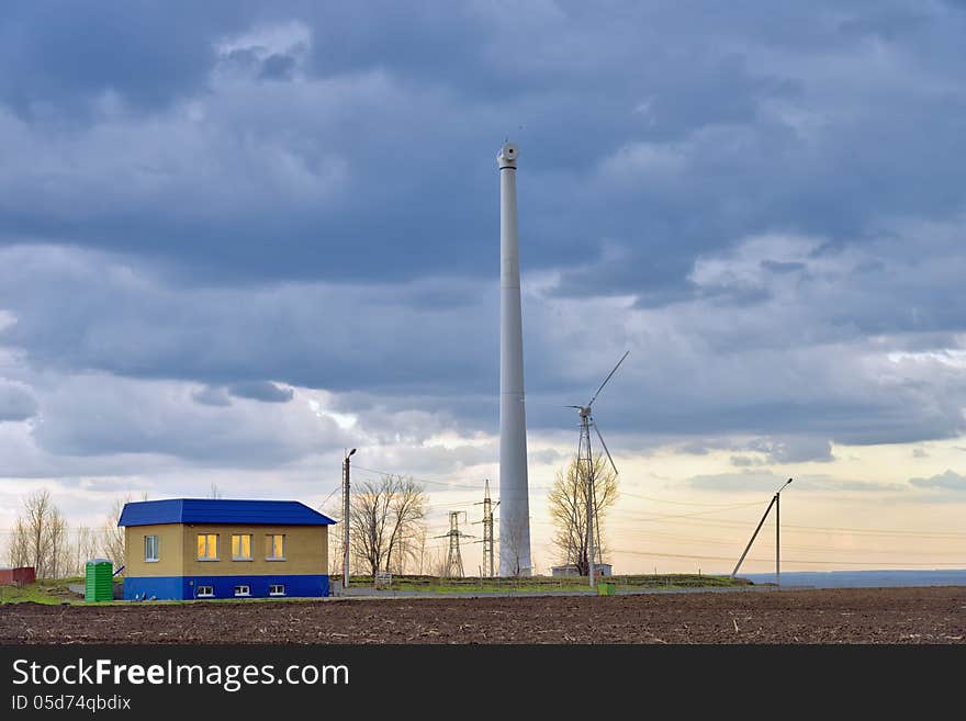 Wind power plant near the house in the field. Two wind turbine for safety.