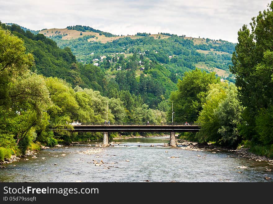 Landscape with mountains trees and a bridge through river. Landscape with mountains trees and a bridge through river