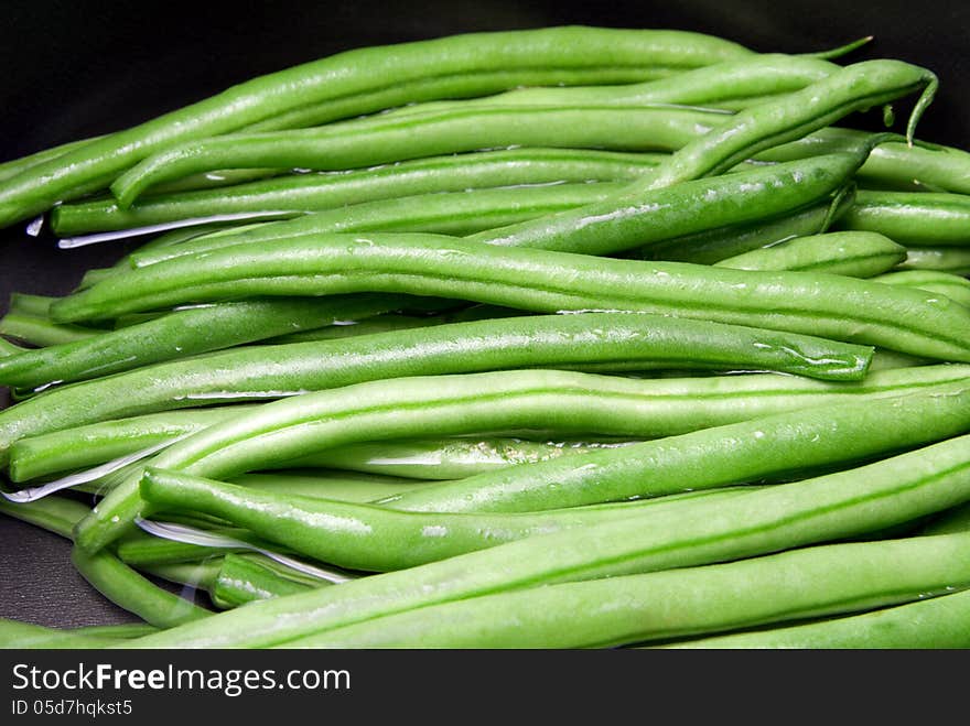 Boiling green beans in a black pan. Boiling green beans in a black pan