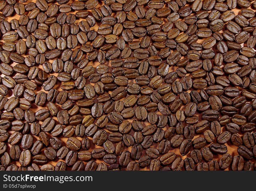 The photograph shows a pattern made out of coffee beans scattered. The photograph shows a pattern made out of coffee beans scattered.