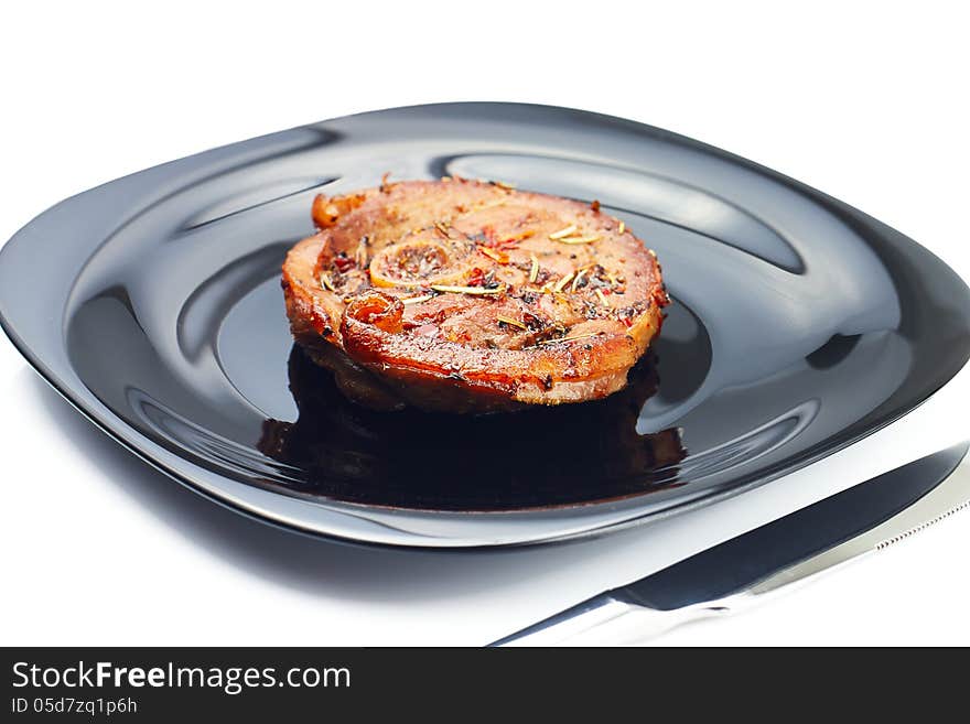 Grilled meat steak at black plate with knife on white background. Grilled meat steak at black plate with knife on white background