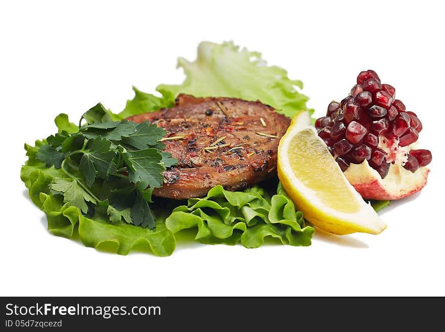 Grilled steak with salad, lemon and pomegranate on white background. Grilled steak with salad, lemon and pomegranate on white background