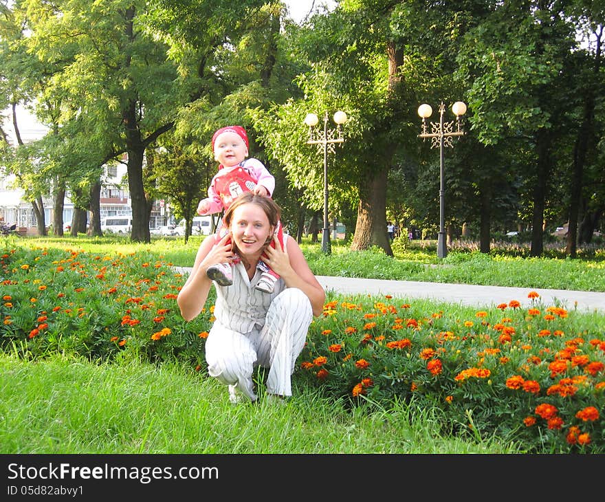 Happy mum and the daughter in park with flowers