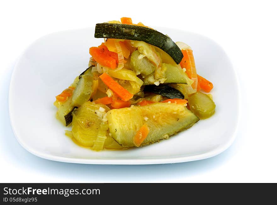 Ragout with Zucchini, Carrot, Leek and Bell Pepper on Square White Plate isolated on white background