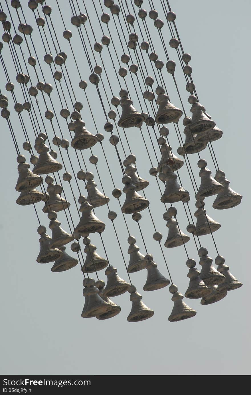 Low angle view of hanging bells with the sky in the background