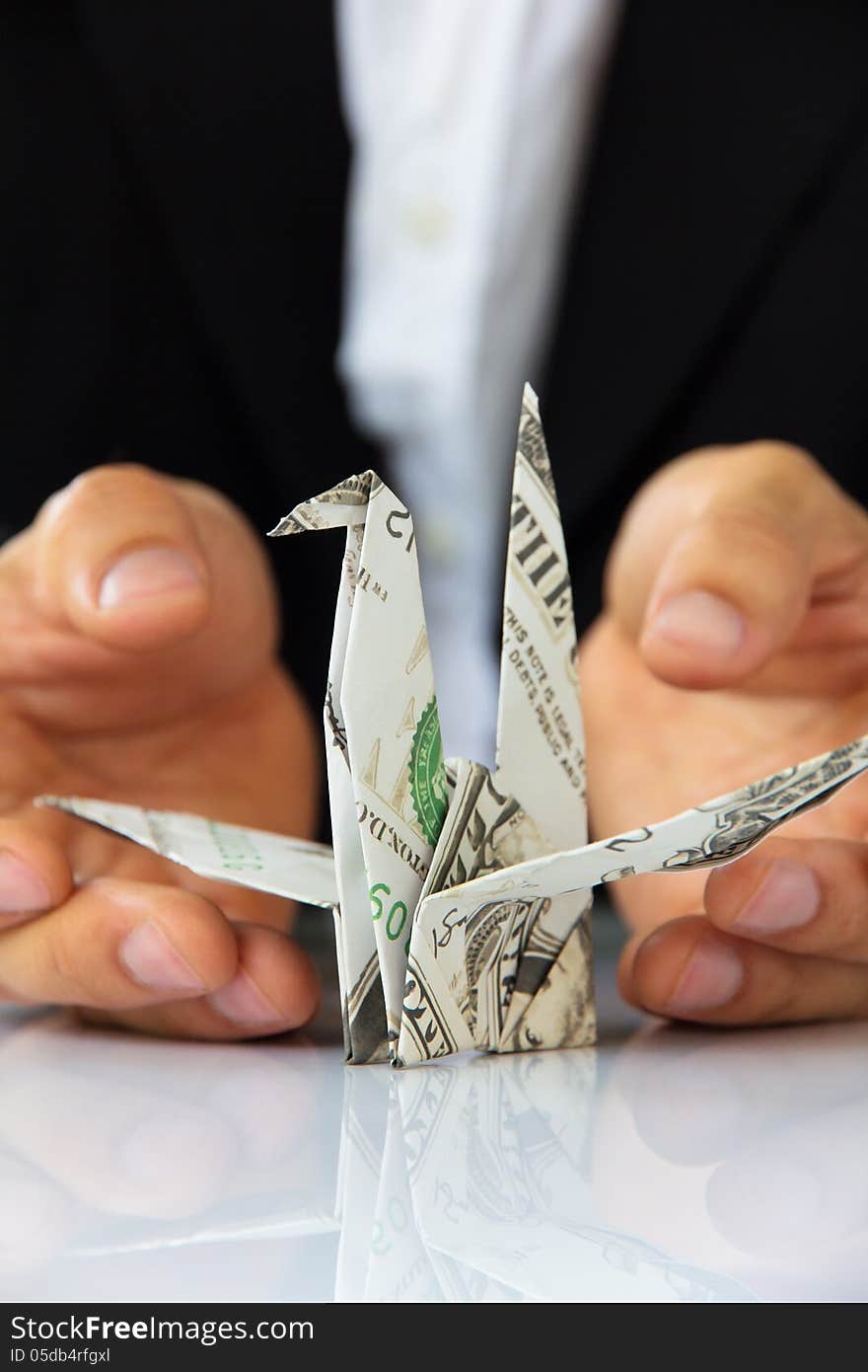 Business man hand holding origami paper cranes, money concept