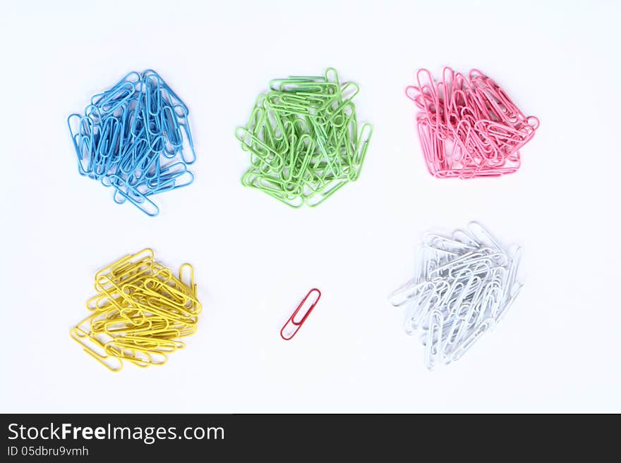 Piles of colour clippers and a single of red clipper isolated on white background