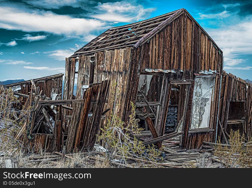 Leaning rundown cabin with dramatic sky in background in Randsberg California. Leaning rundown cabin with dramatic sky in background in Randsberg California