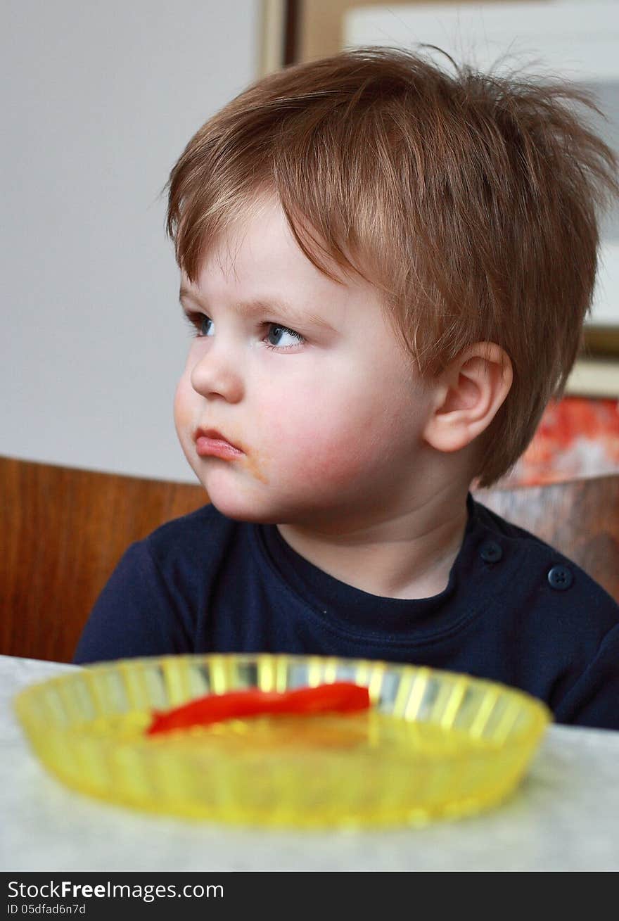 Little boy eating sweet and has a dirty mouth