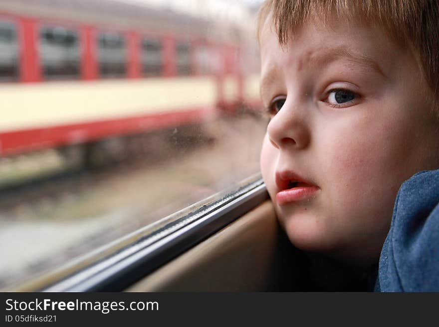 Little boy looking out the train window