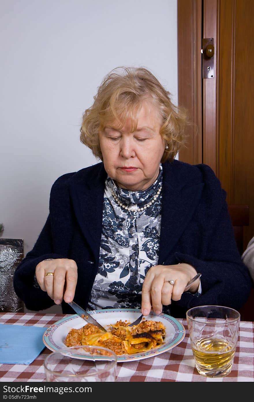 Elderly woman at table eating