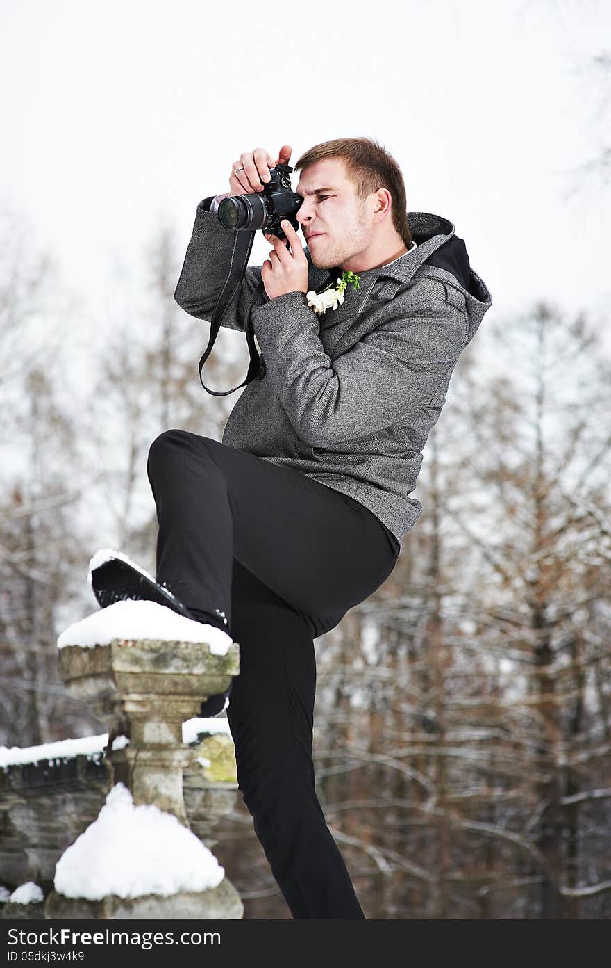 Young man with a camera at winter