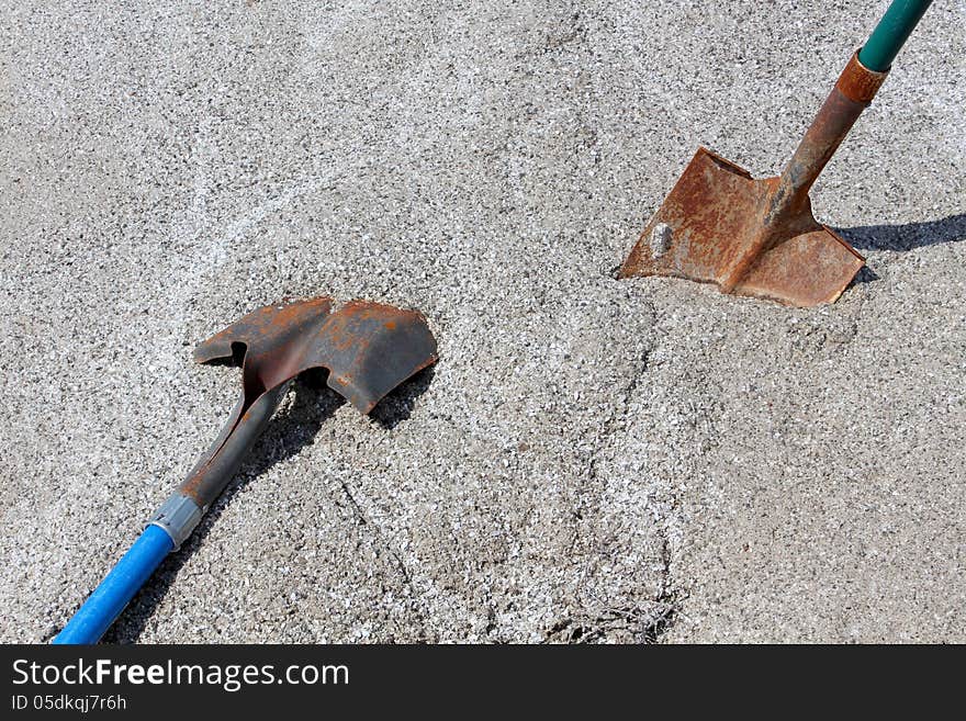 Two work shovels in mound of gravel.