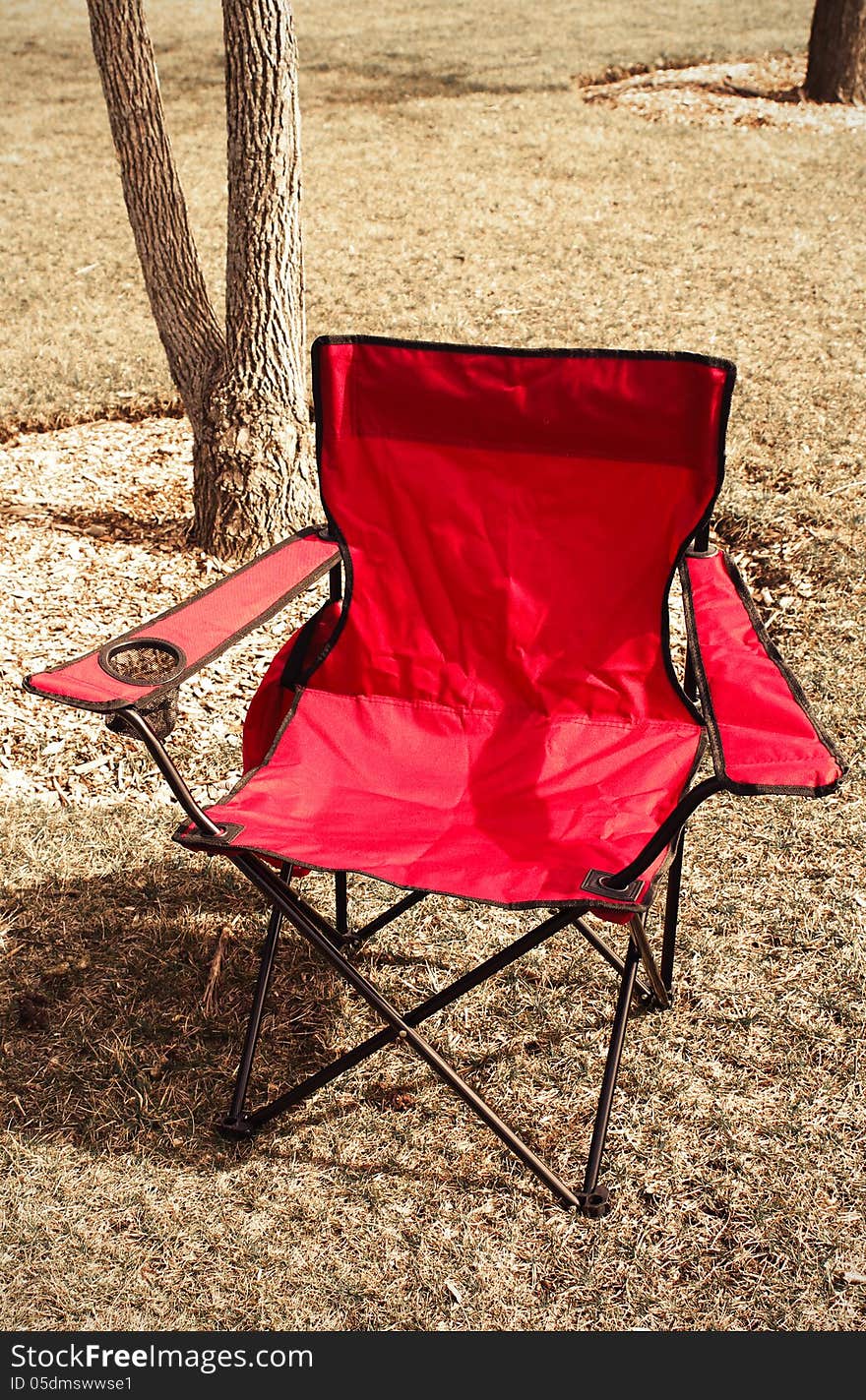 Red camping chair in the park