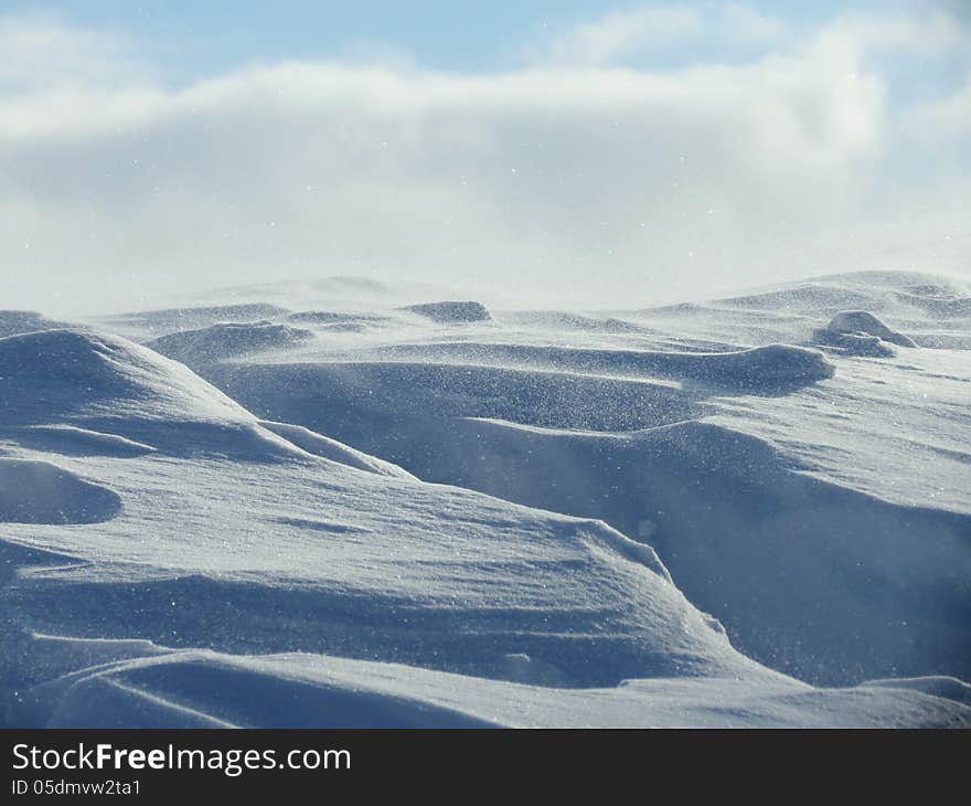 Strong wind with snow drifts in the steppes namelo Altai