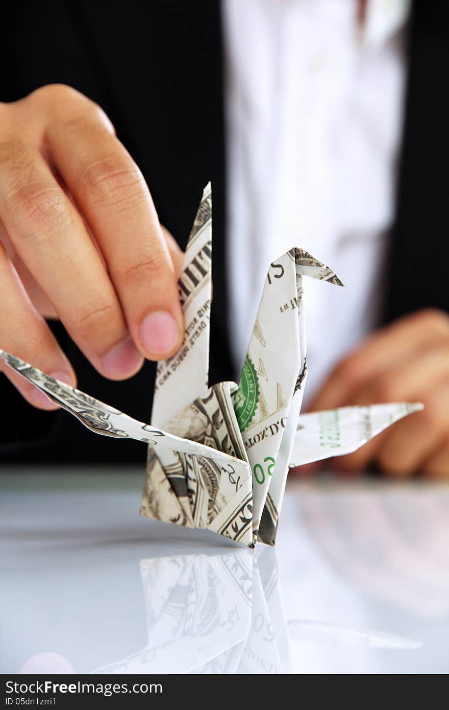 Business man hand holding origami paper cranes, money concept