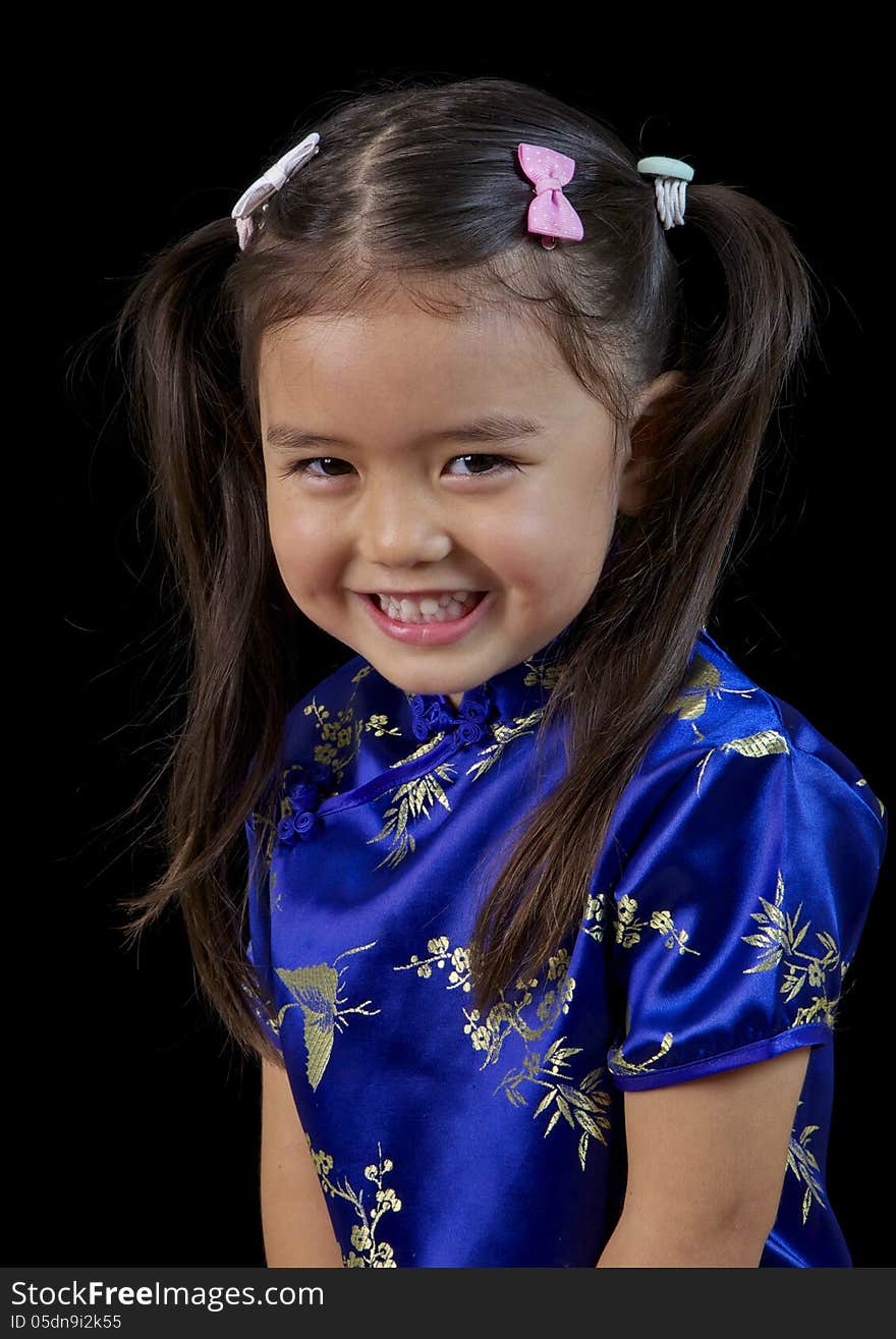 Smiling portrait of a little Philippino girl in a blue silk dress