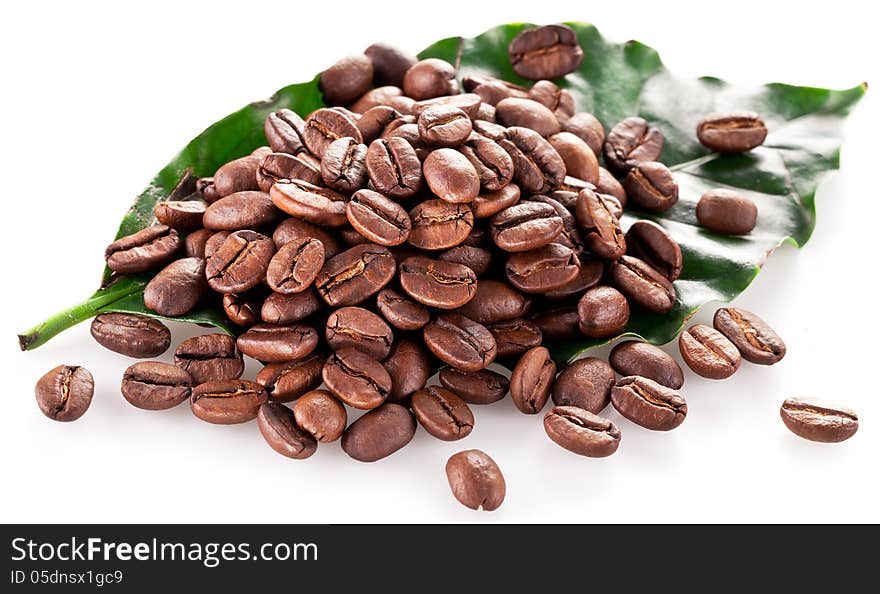 Coffee beans on leaf. Closeup snapshot on a white background.