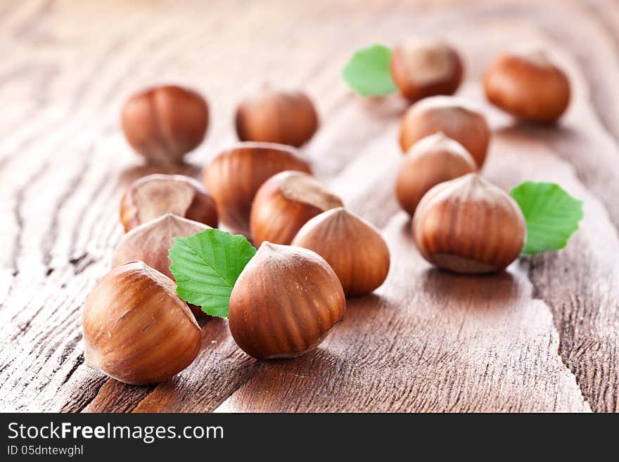 Filberts with leaves on a wooden table. Close-up shot. Filberts with leaves on a wooden table. Close-up shot.