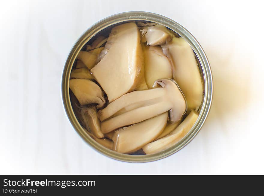 Open tin can of sliced mushrooms. Open tin can of sliced mushrooms