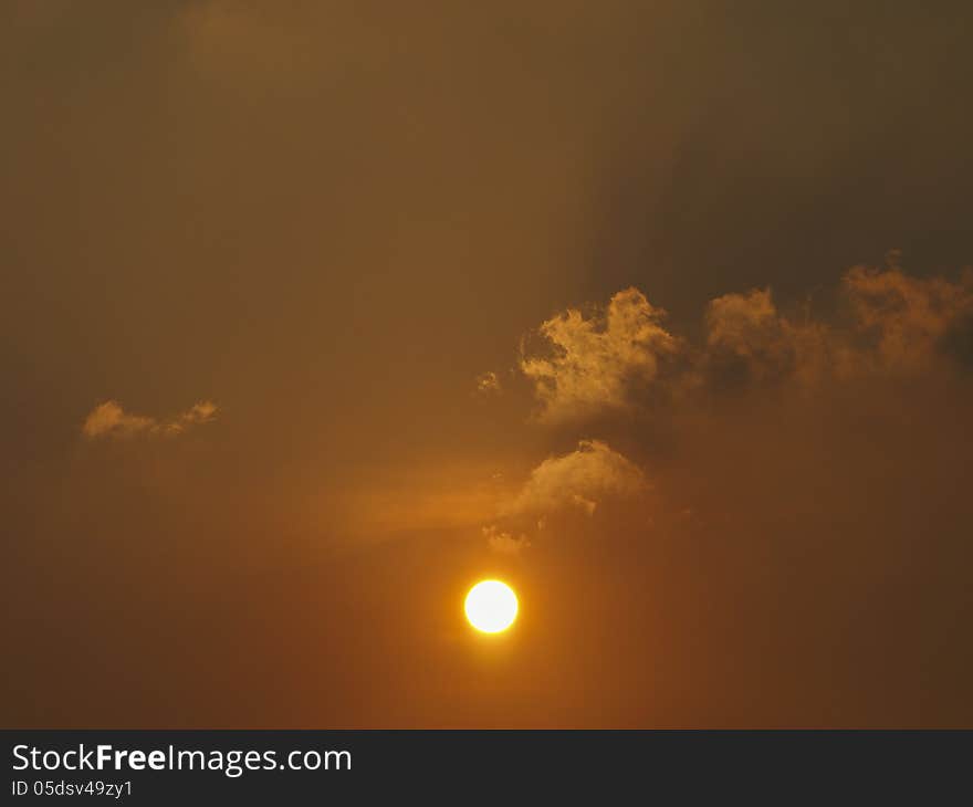 View of orange sun in orange sky with cloud. View of orange sun in orange sky with cloud