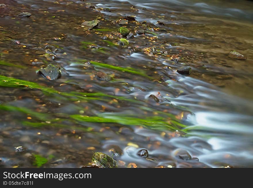 Flowing water with rocks in the creek. Flowing water with rocks in the creek