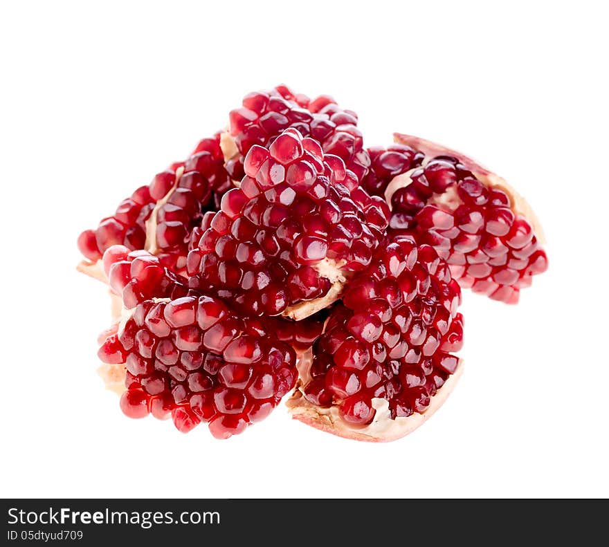 Pieces of the pomegranate fruit folded a heap on the white background