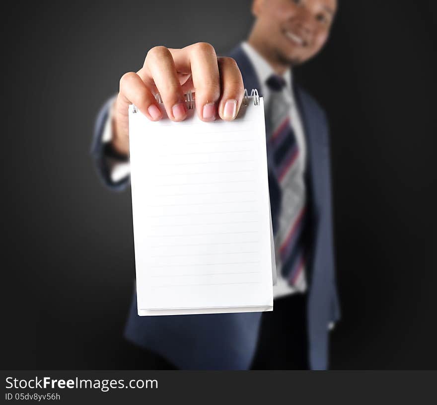 Business man showing note paper. With dark background