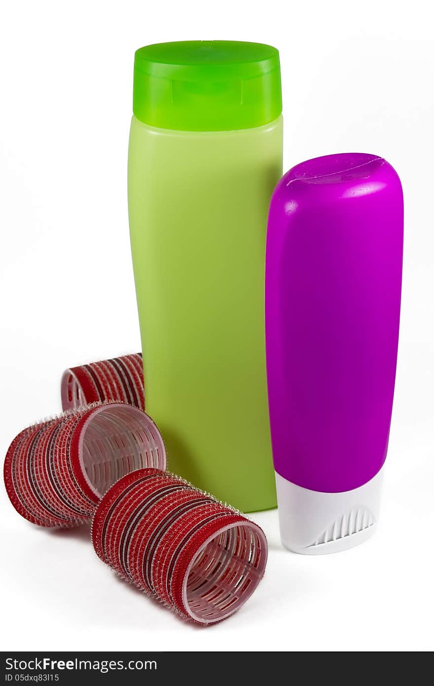 Bottles of shampoo and conditioner with big curlers on white backgroound. Bottles of shampoo and conditioner with big curlers on white backgroound