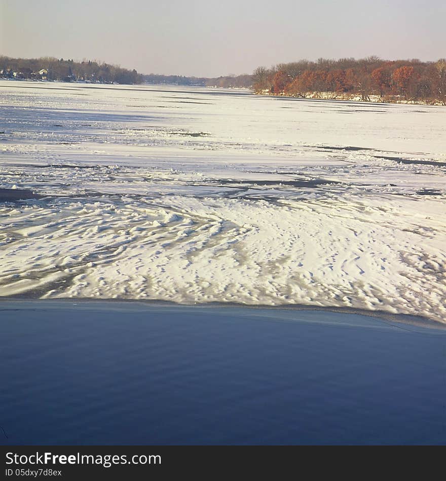 A panoramic winter overlook on the Mississippi River and distant woodlands, at the Coon Rapids Dam Park Reserve in central Minnesota. A panoramic winter overlook on the Mississippi River and distant woodlands, at the Coon Rapids Dam Park Reserve in central Minnesota.