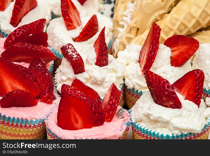 Delicious vanilla cupcake with strawberry frosting and fresh strawberries