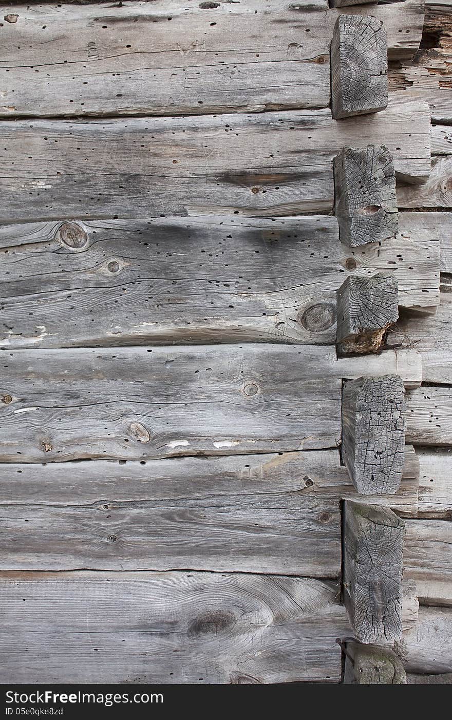 Background - a fragment of an old wooden house, damaged by beetles