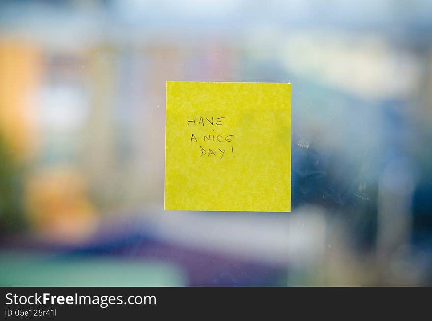 Have a nice day text handwritten on a sticky note against urban background. Have a nice day text handwritten on a sticky note against urban background