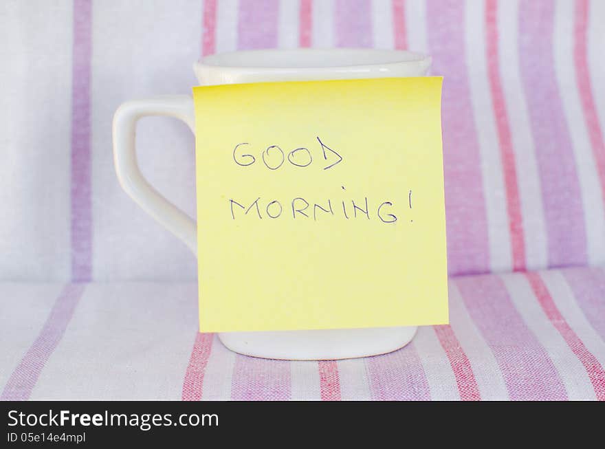 Cup with sticky note Good morning handwritten