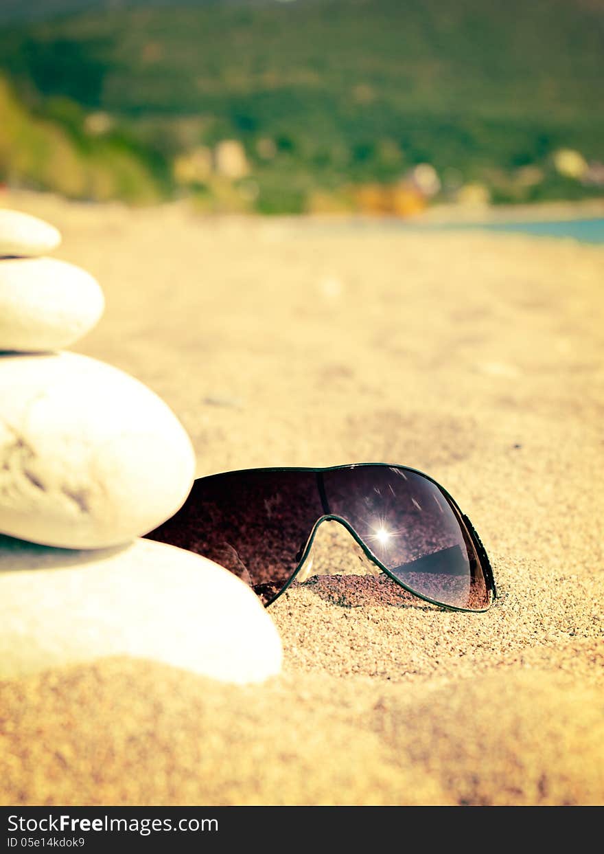 Sea, sandy beach and sunglasses with reflection of the sun. Sea, sandy beach and sunglasses with reflection of the sun