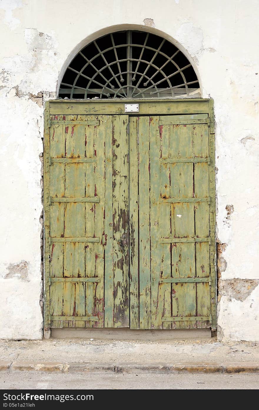 Old green garage door with peeling paintwork