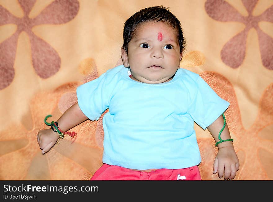 New born baby on colorful bed sheet