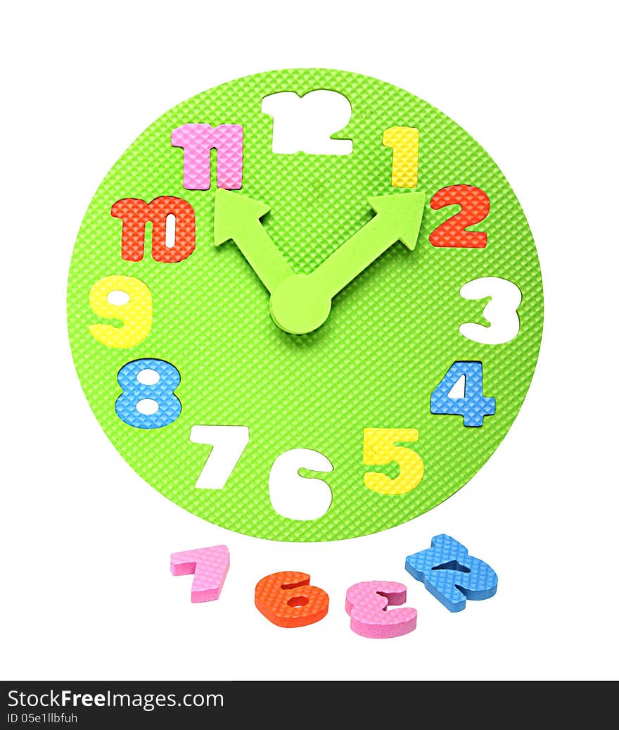 Image of a colorful foam clockface with detachable parts taken out, an educational toy to teach the concept of time to kids. Isolated on white. Clipping path included.