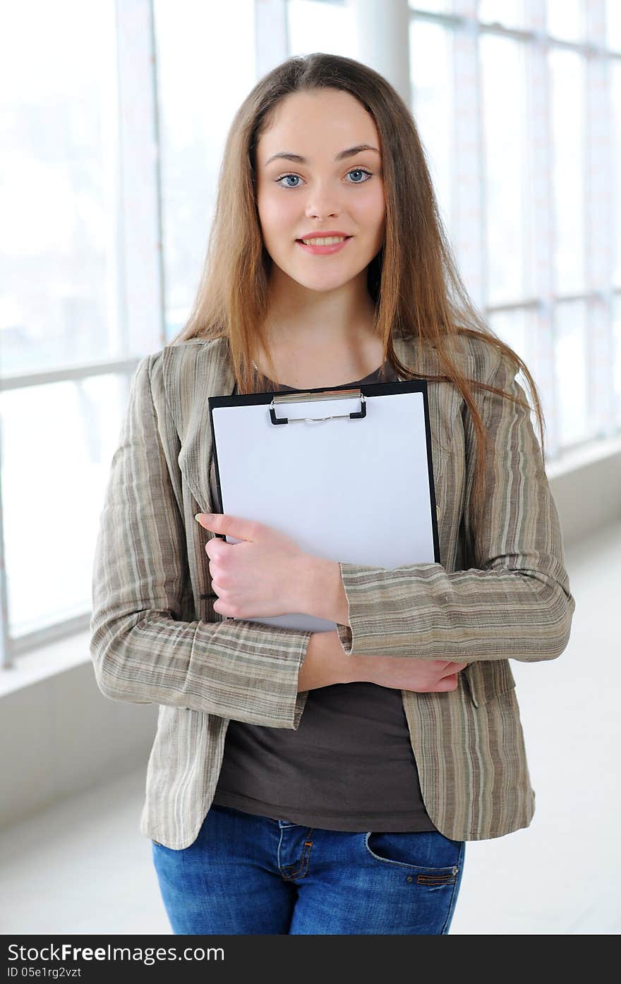 Young business girl with a folder in hands at office