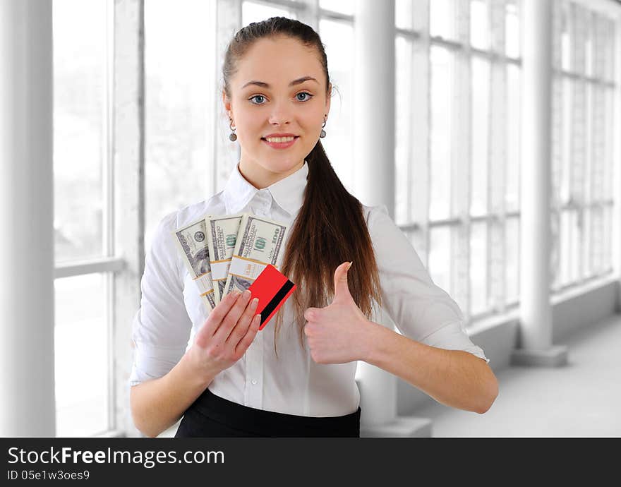 Portrait of a young business girl with money in the office