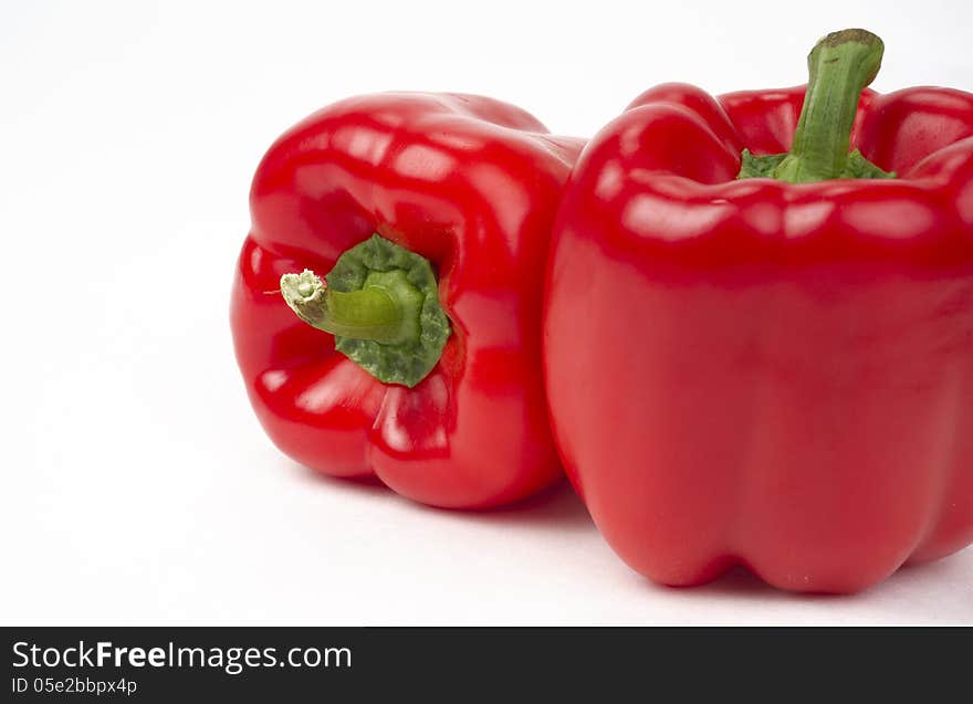 Pair Of Bright Fresh Red Peppers Food Sits On White