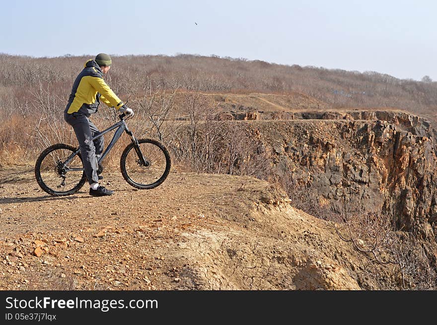 Single rider in yellow sport coat standing on the rock. Single rider in yellow sport coat standing on the rock